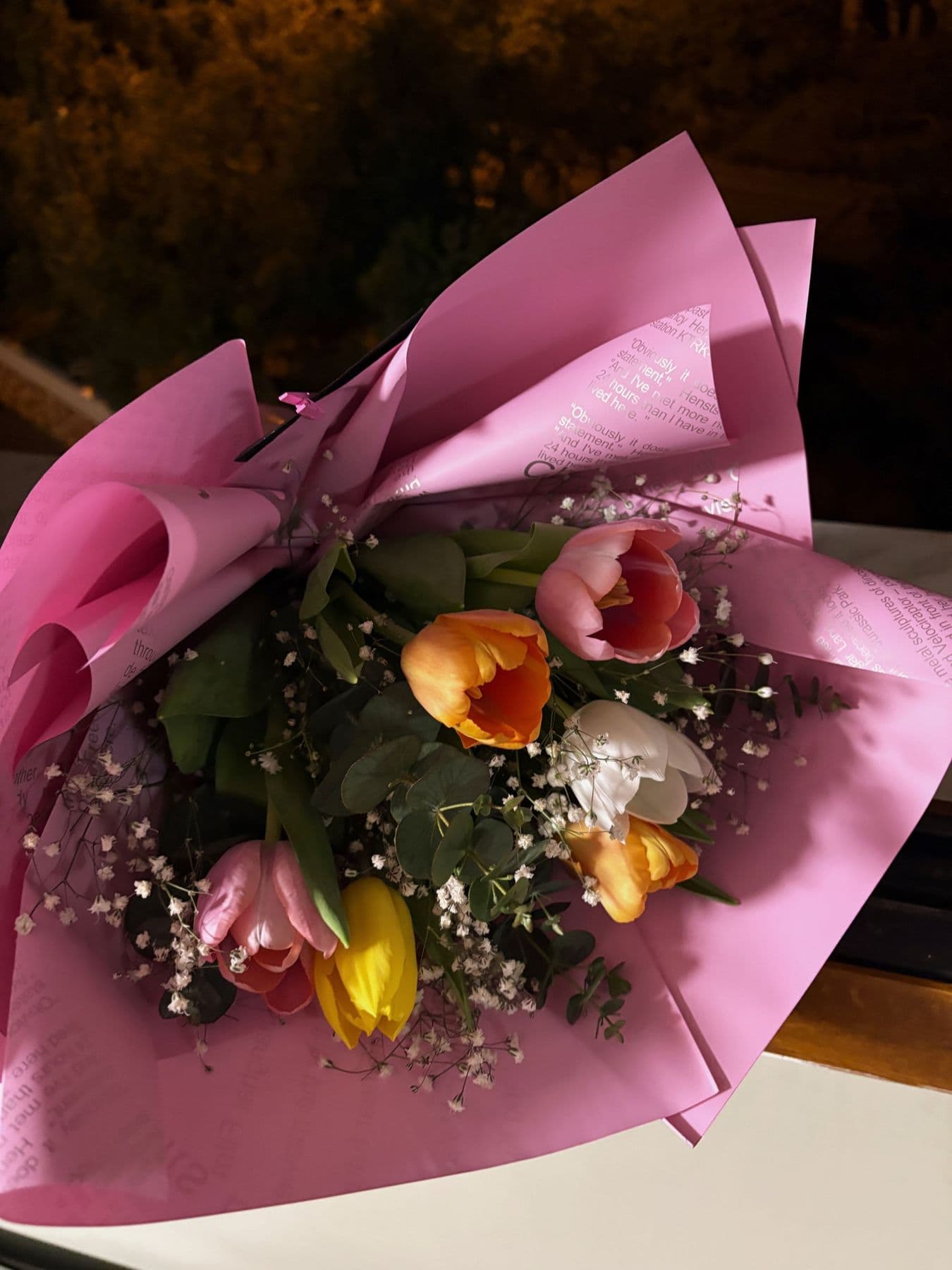 Mixed tulips and gypsophila wrapped in pink paper
