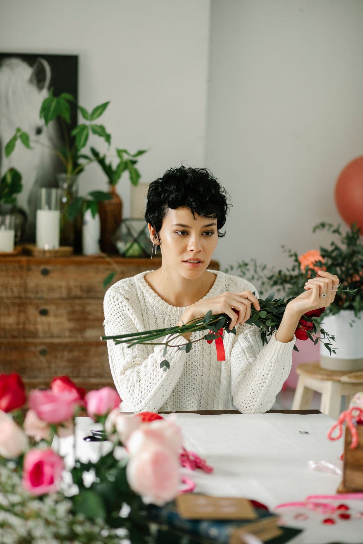 Florist arranging roses at a table in the studio