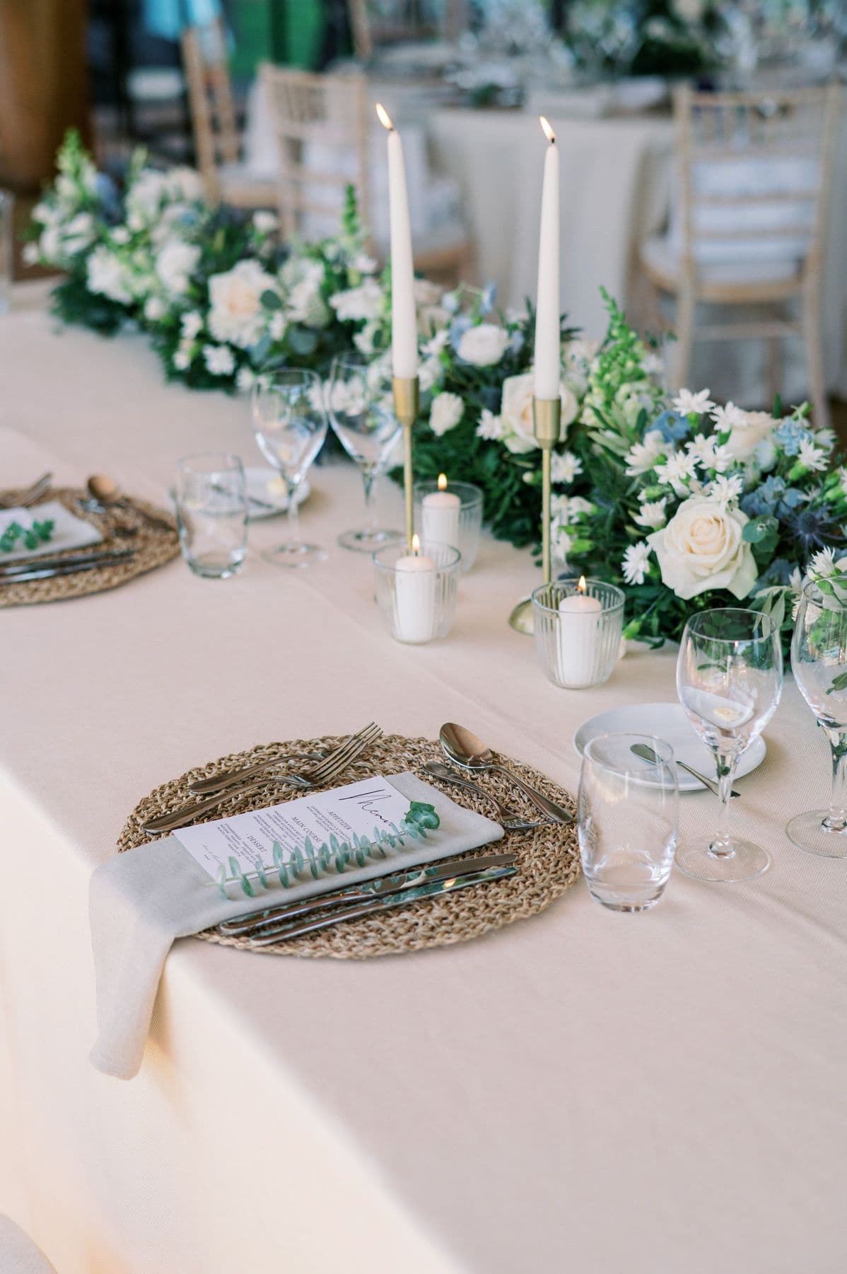 Long wedding table with cream flowers, eucalyptus and tall candles